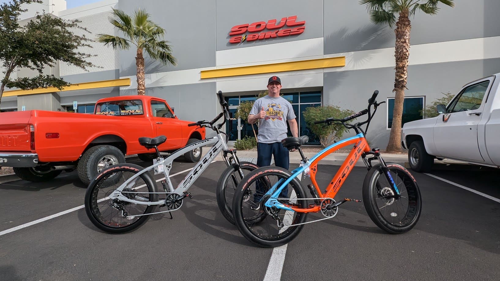 Man with two bicycles outside a store.