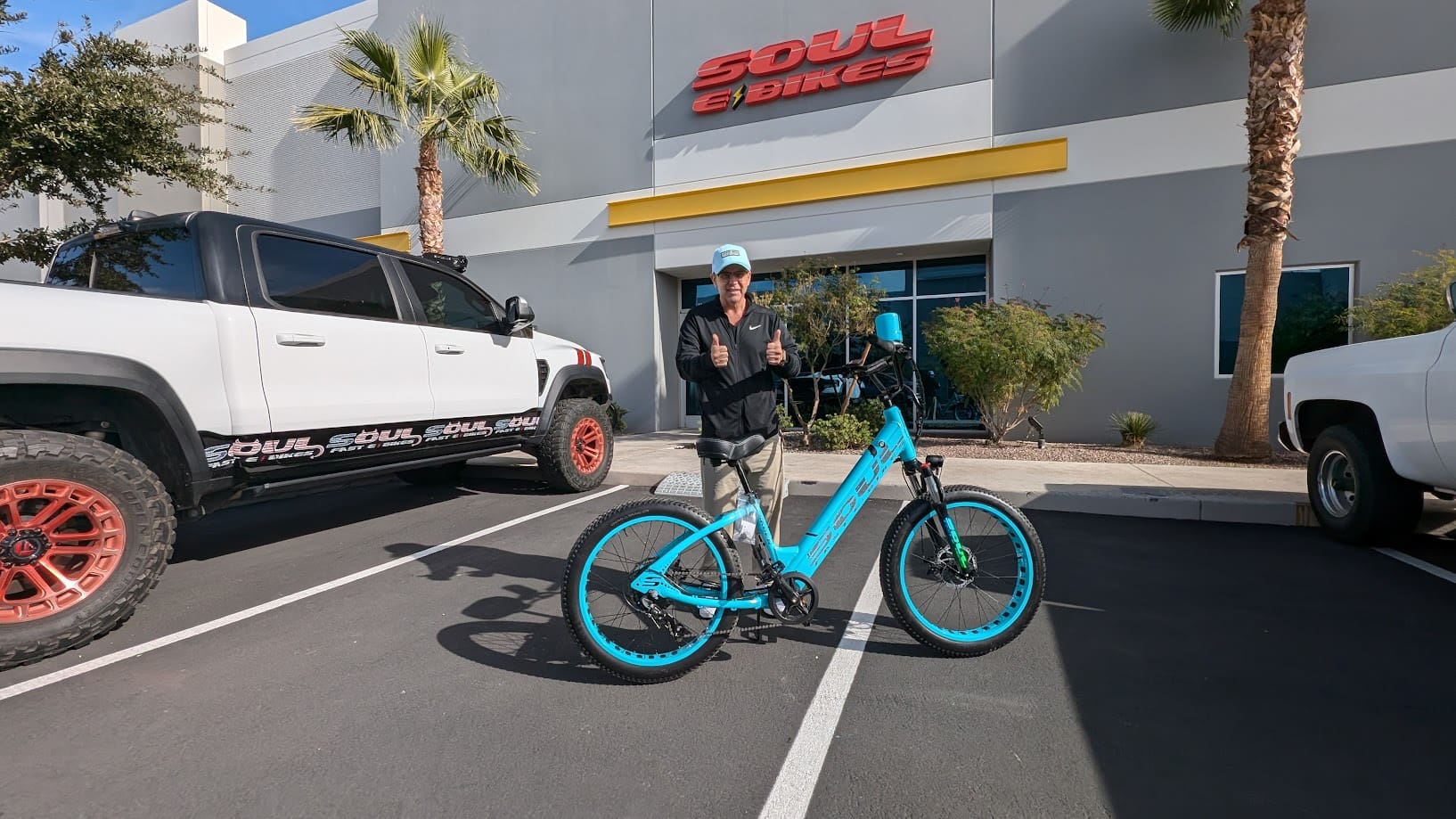 Person with electric bike outside bike shop.