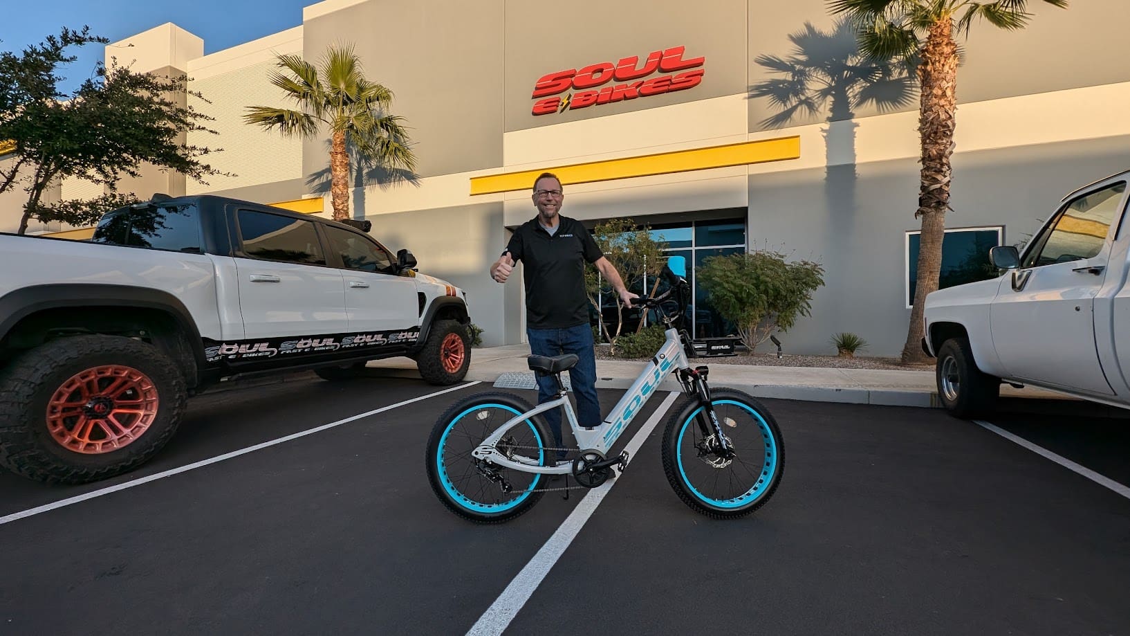 Man with bicycle outside a fitness store.
