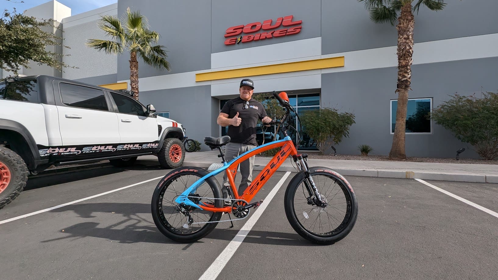 Man with bike outside Soul Beach Cruisers store.