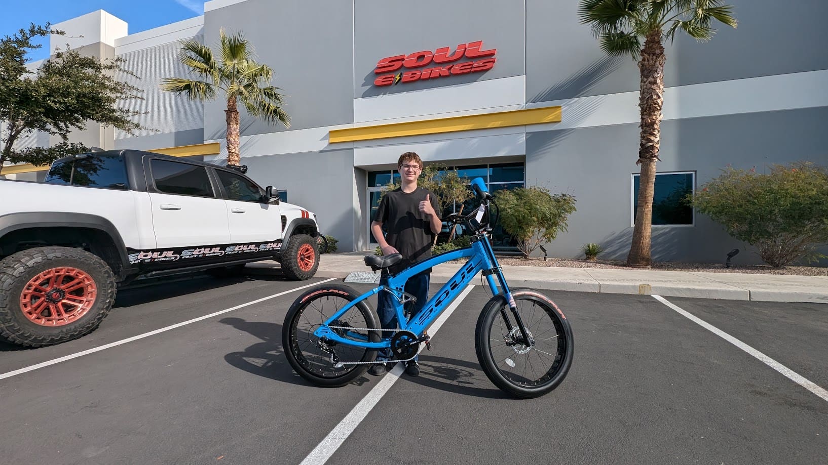 Person with a blue bike outside store.