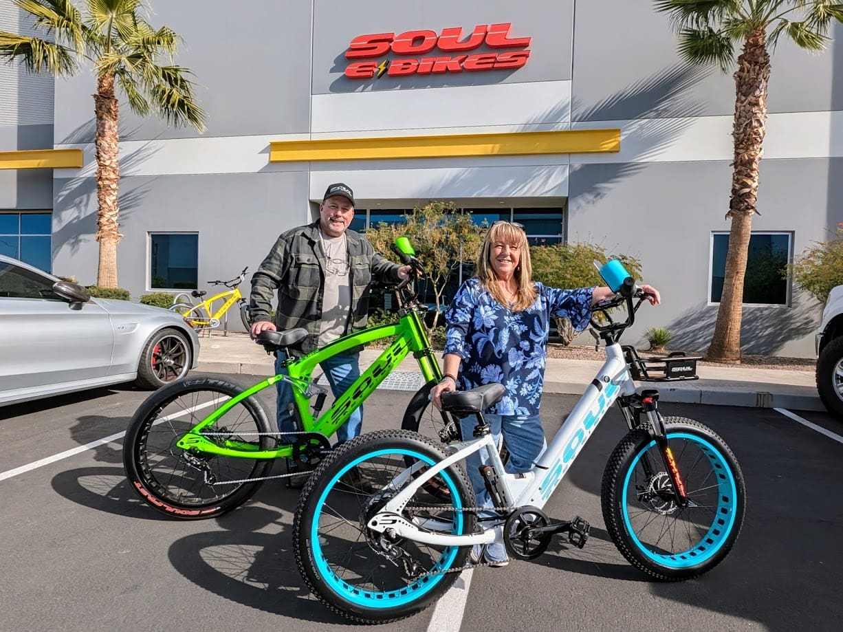 Couple with electric bikes outside Soul Bikes.