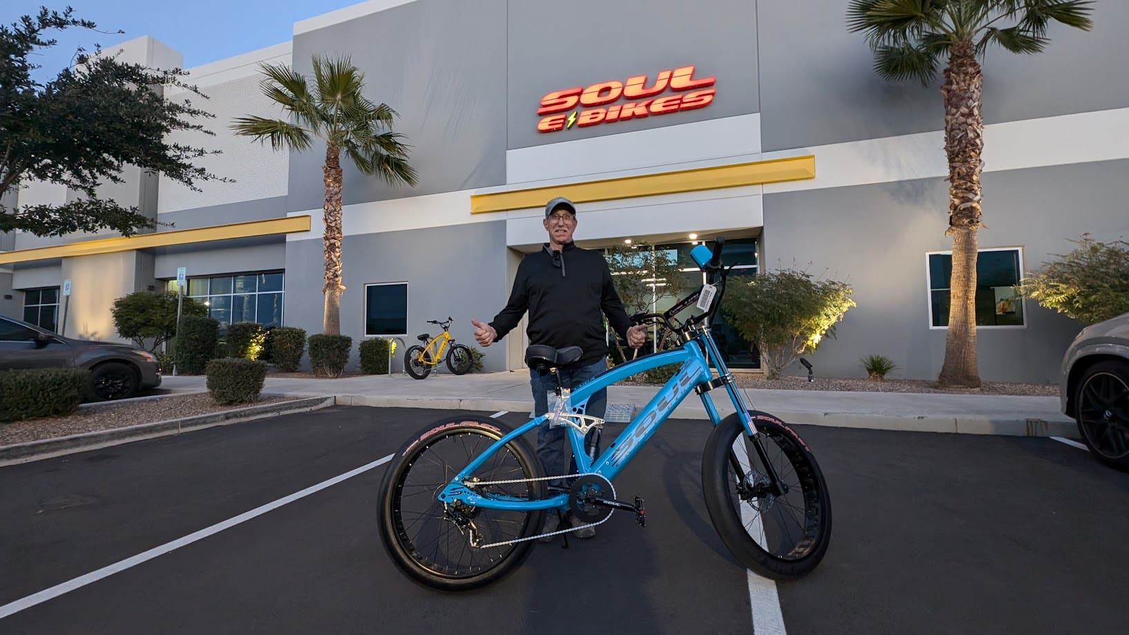 Man with blue bike outside Soul Bikes store.