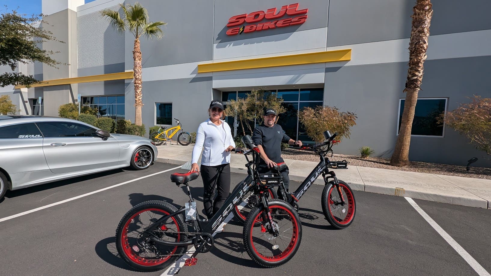 Two people with bikes outside a store.