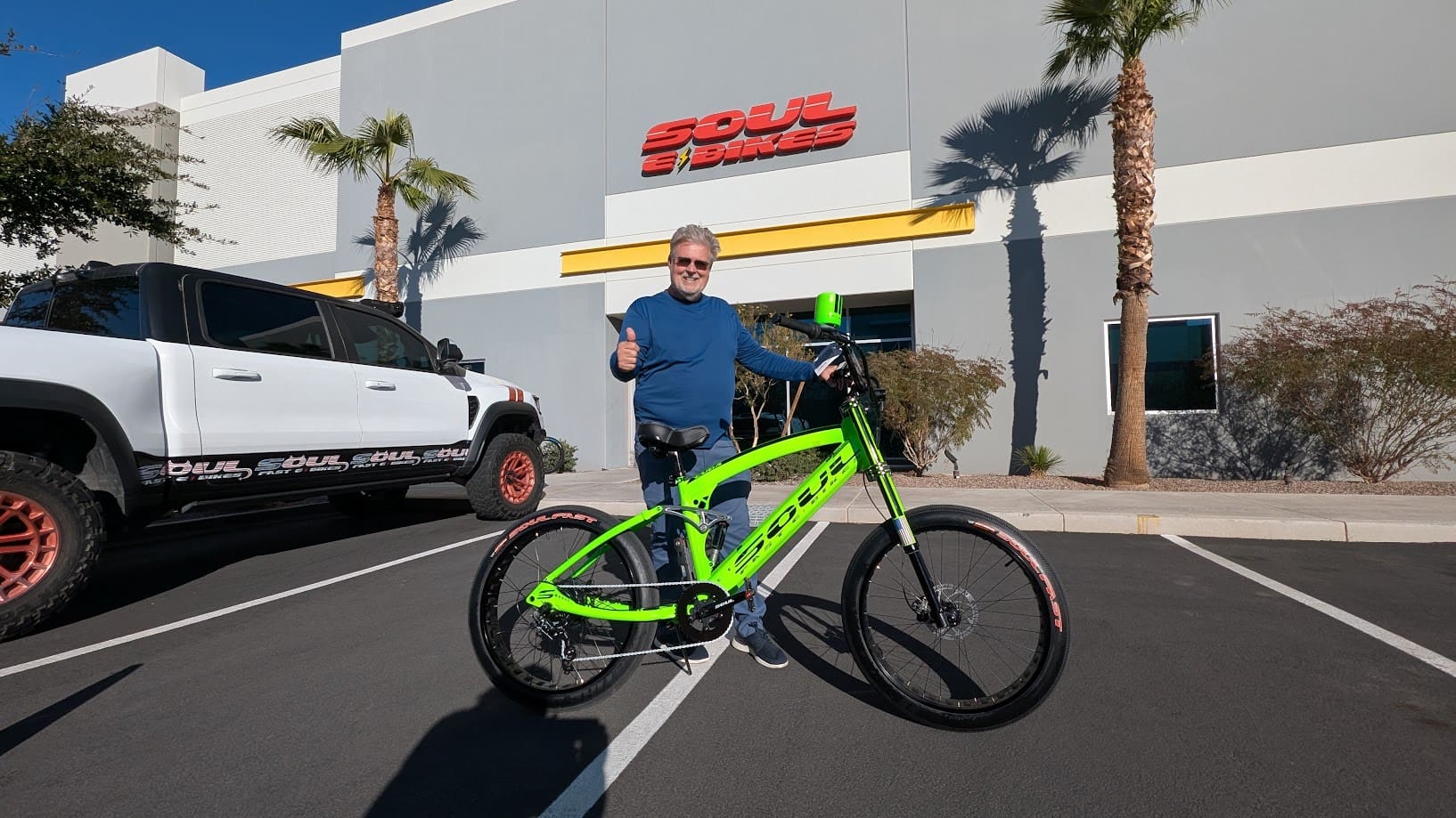 Man with green bike outside a building.