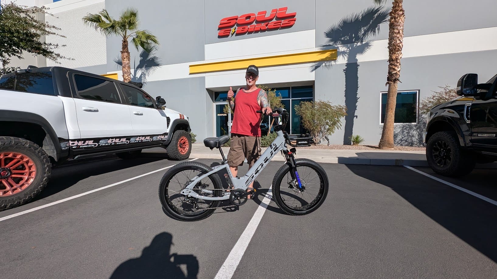 Person with bicycle outside Soul Beach Cruisers building.