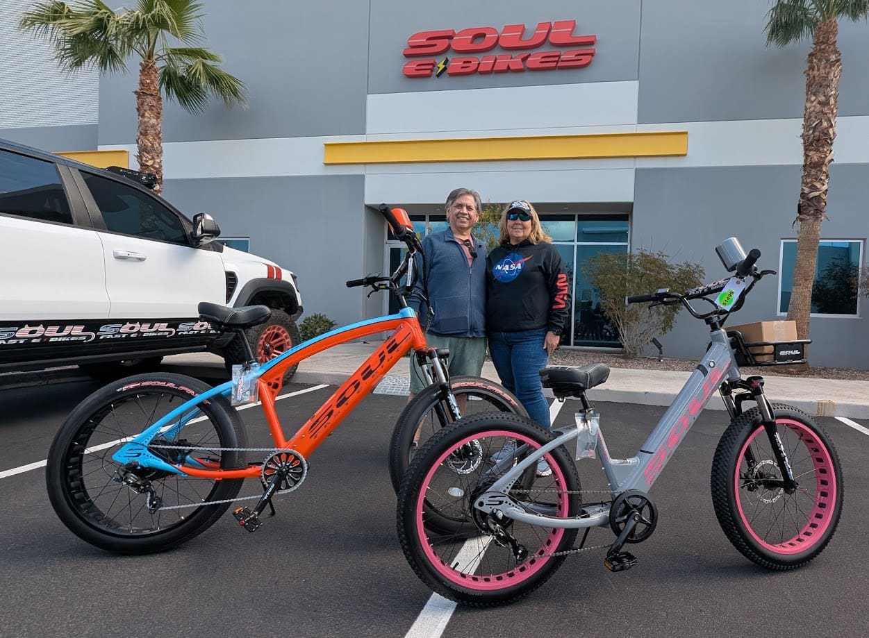 Two people with bicycles outside Soul Bikes.