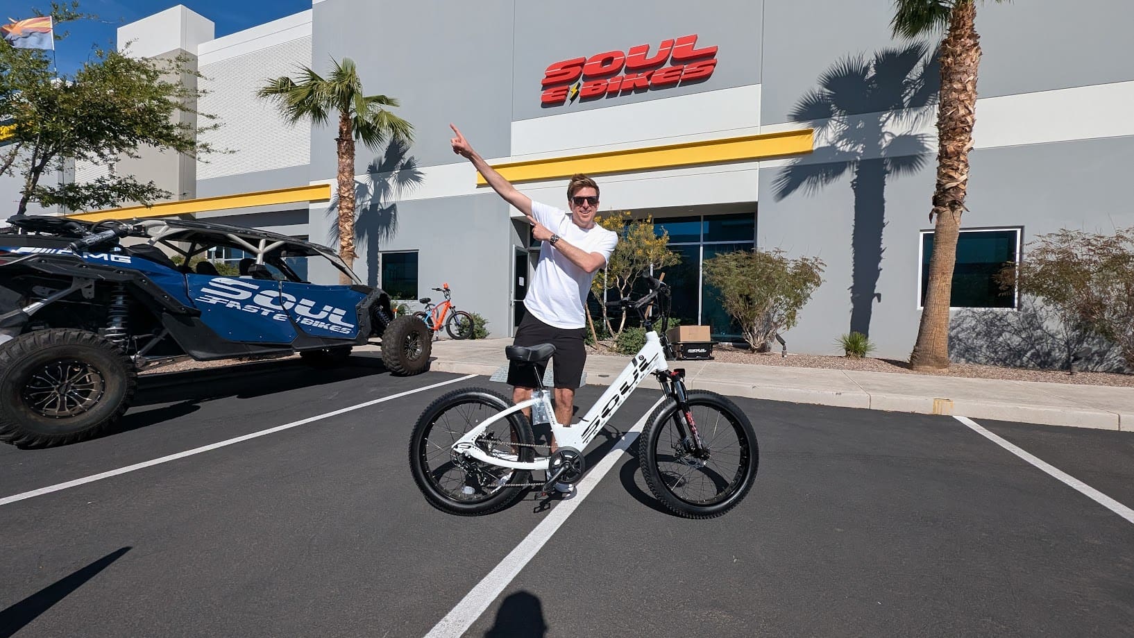 Man posing with bicycle outside Soul eBikes store.
