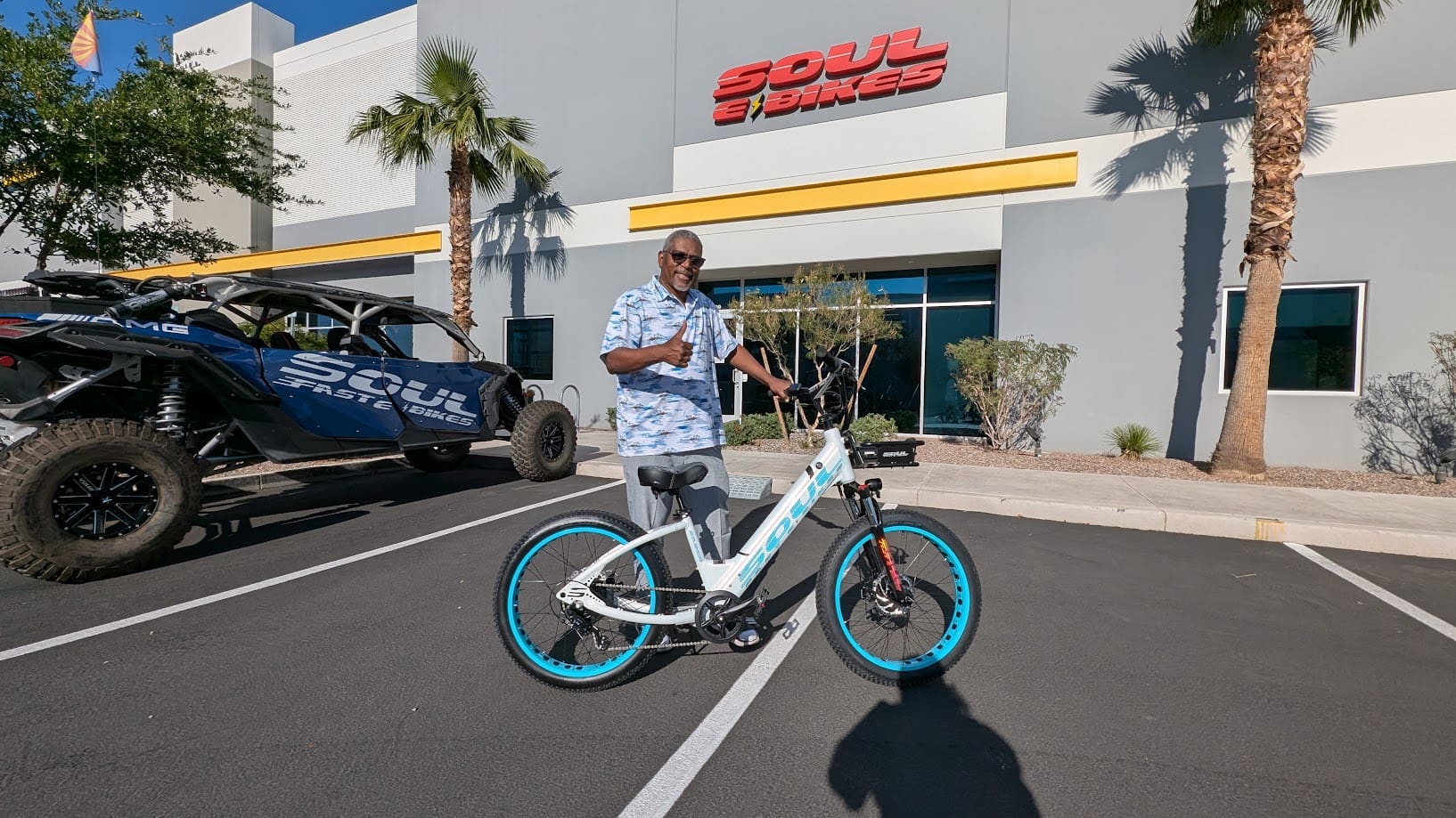 Man standing with bicycle outside a store.