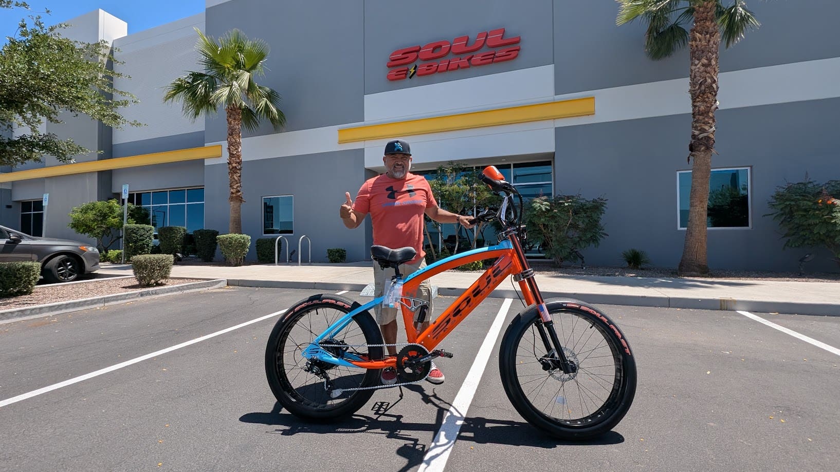 Man with bicycle outside Soul E Bikes building.