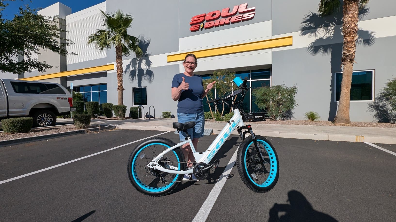 Person with bicycle outside Soul e Bikes store.