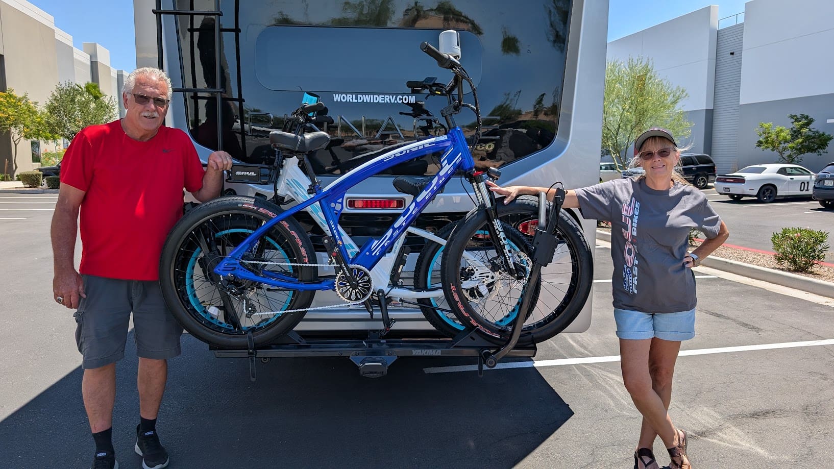 Two people with bikes on RV rack.