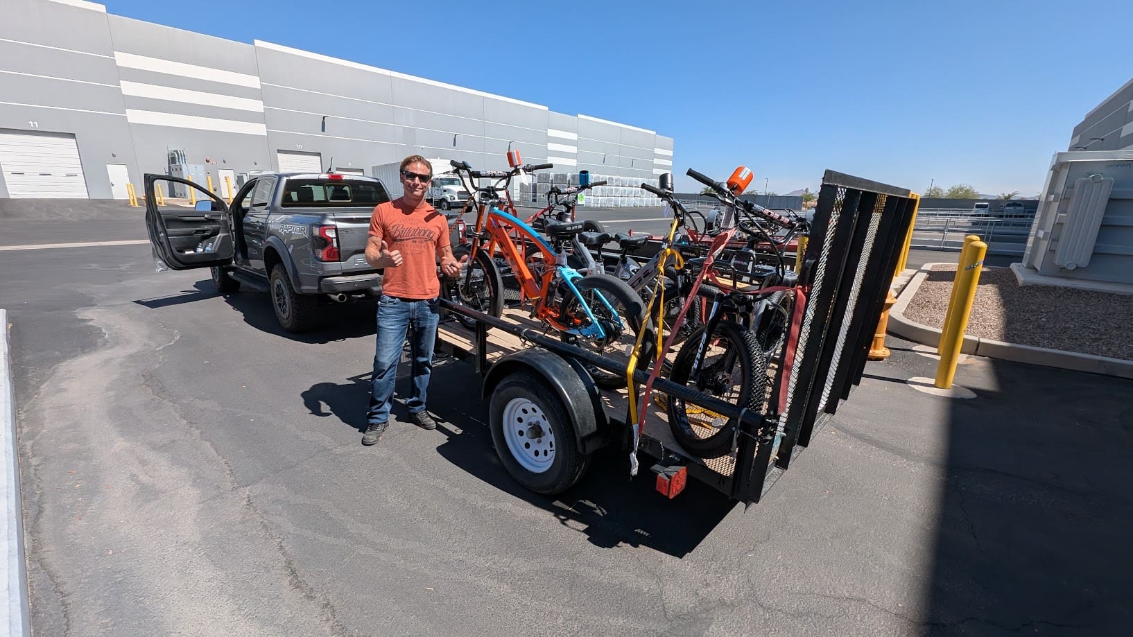 Man standing by truck with bike trailer.