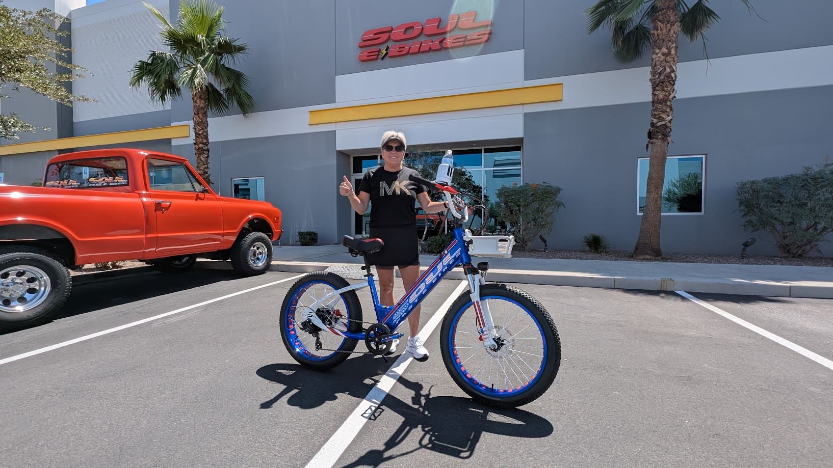 Person with bicycle outside Soul Bikes building.