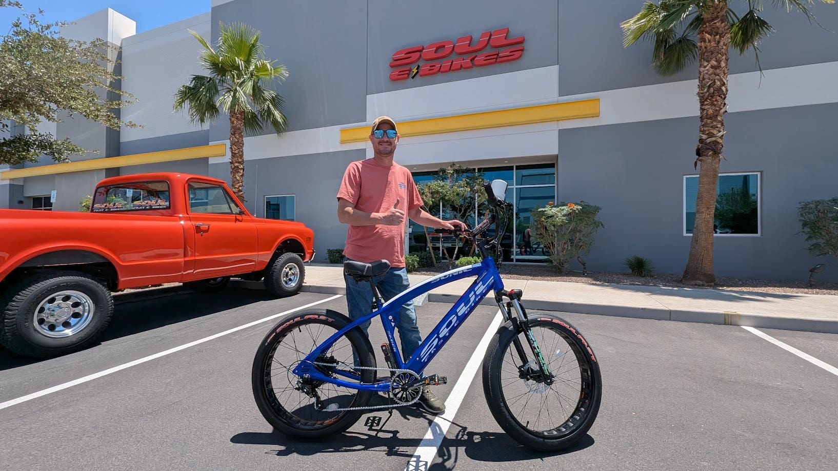 Man with blue bike outside Soul Bikes store.