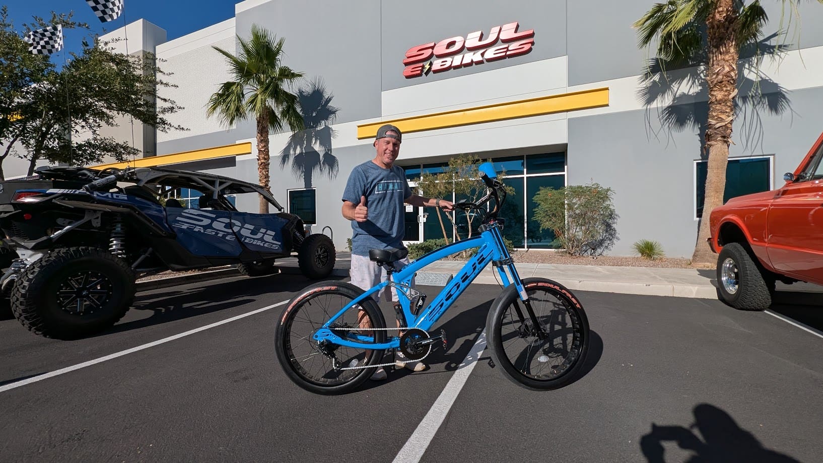 Man with blue bike outside Soul Bikes store.