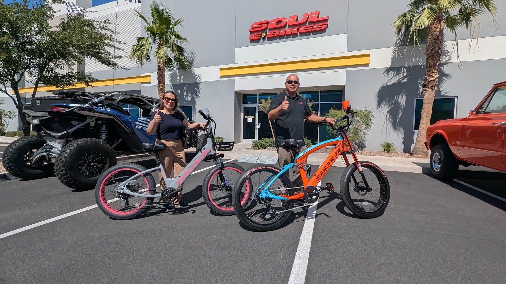 Two people with bikes outside a shop.