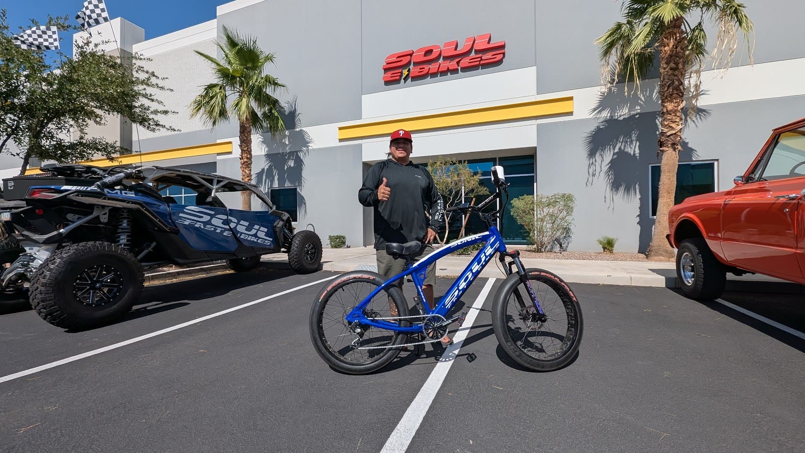 Man standing with bike outside shop.