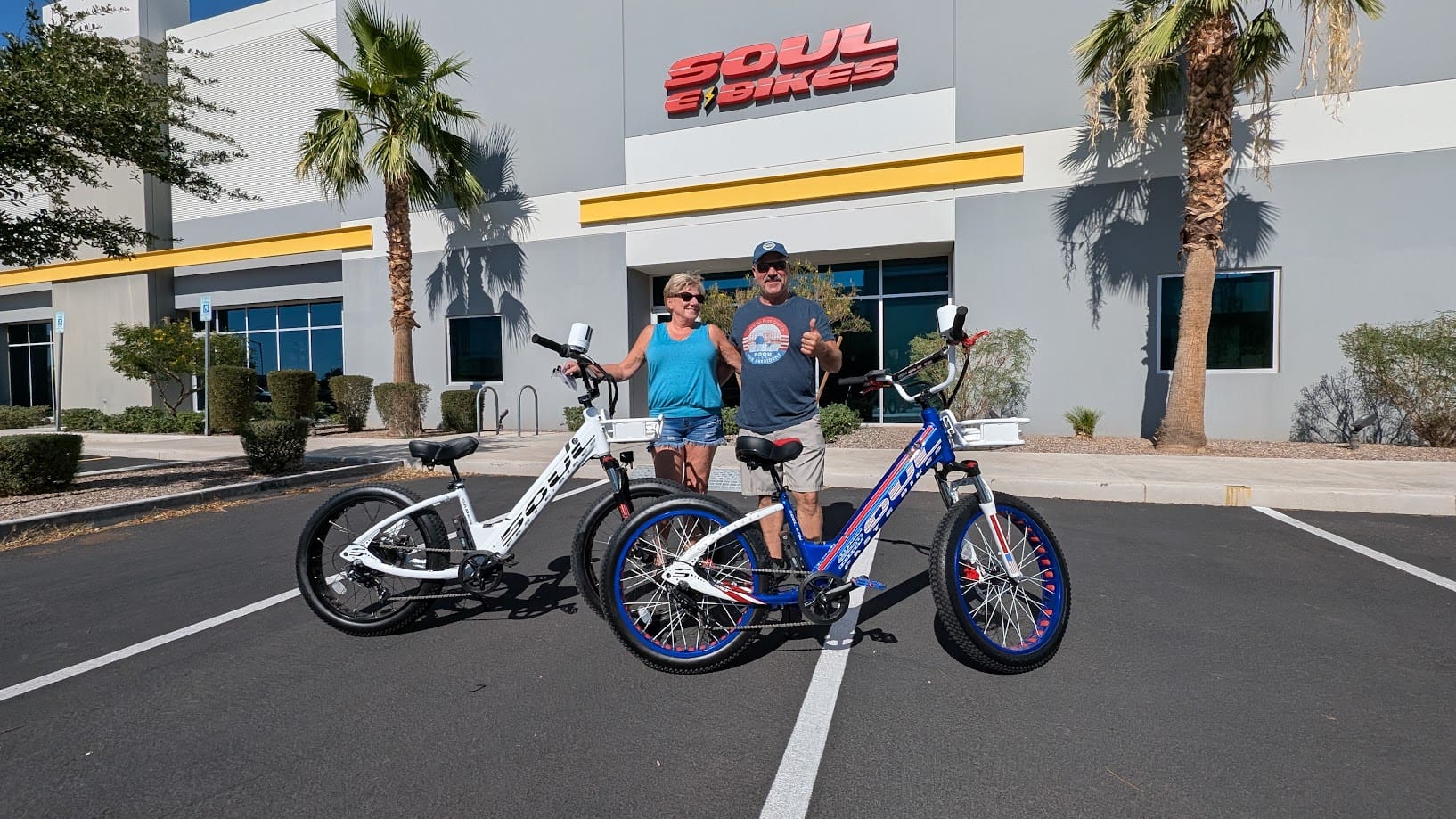 Two people with bicycles outside a store.