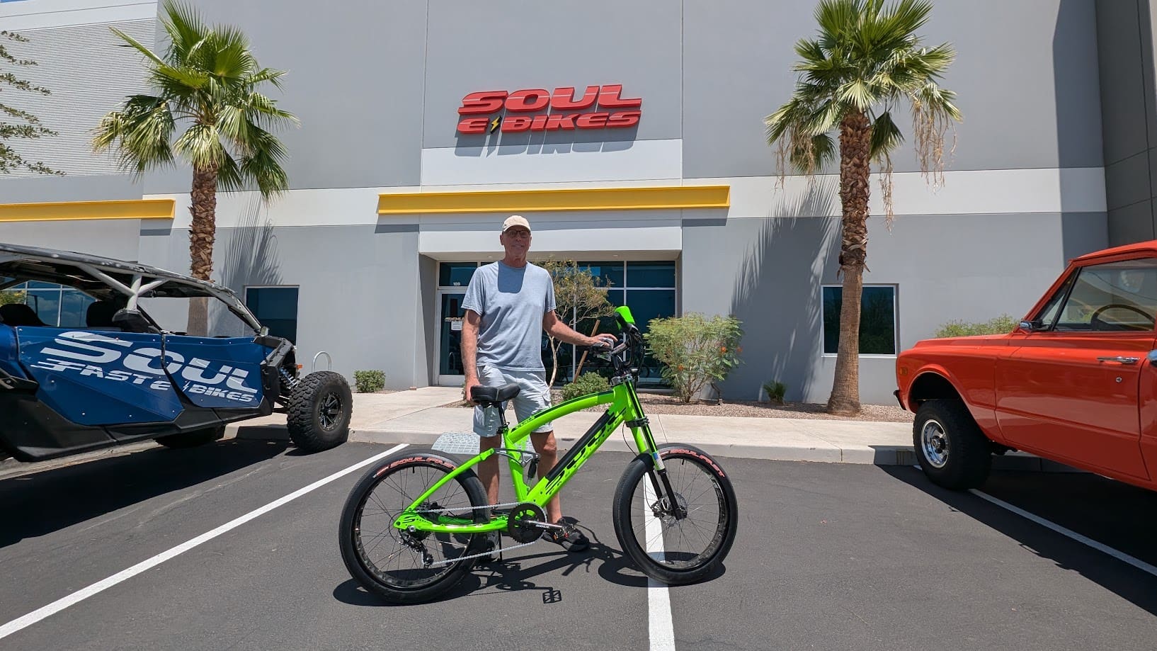 Man with green bike outside Soul eBikes store.