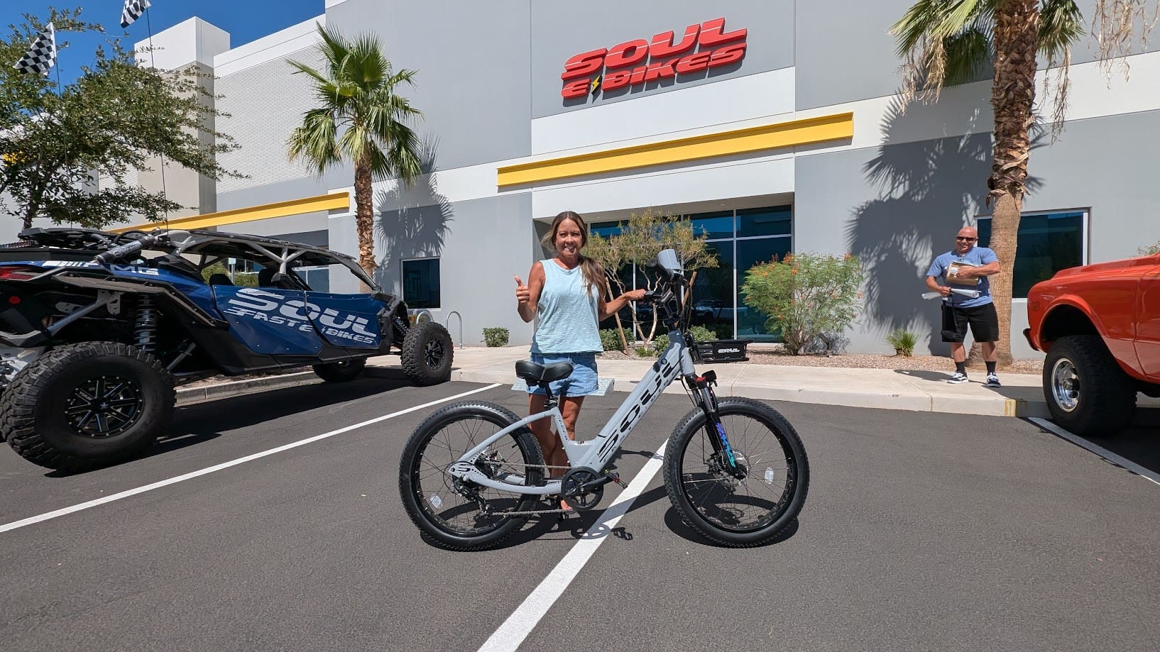 Person posing with bicycle outside store.