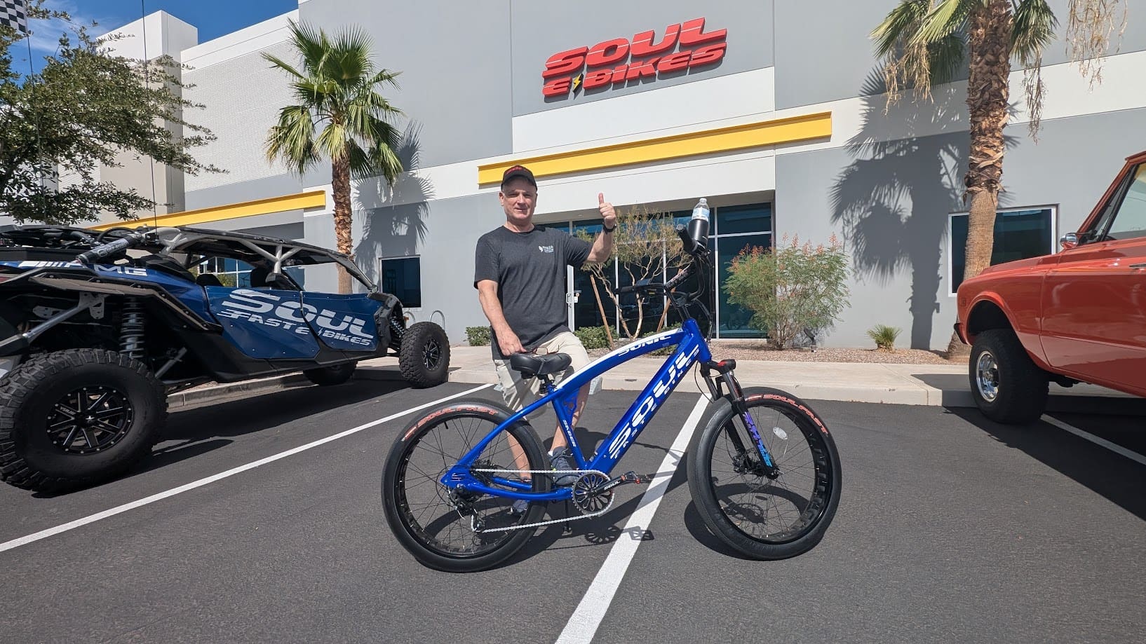 Man with blue bike outside Soul Bikes store.