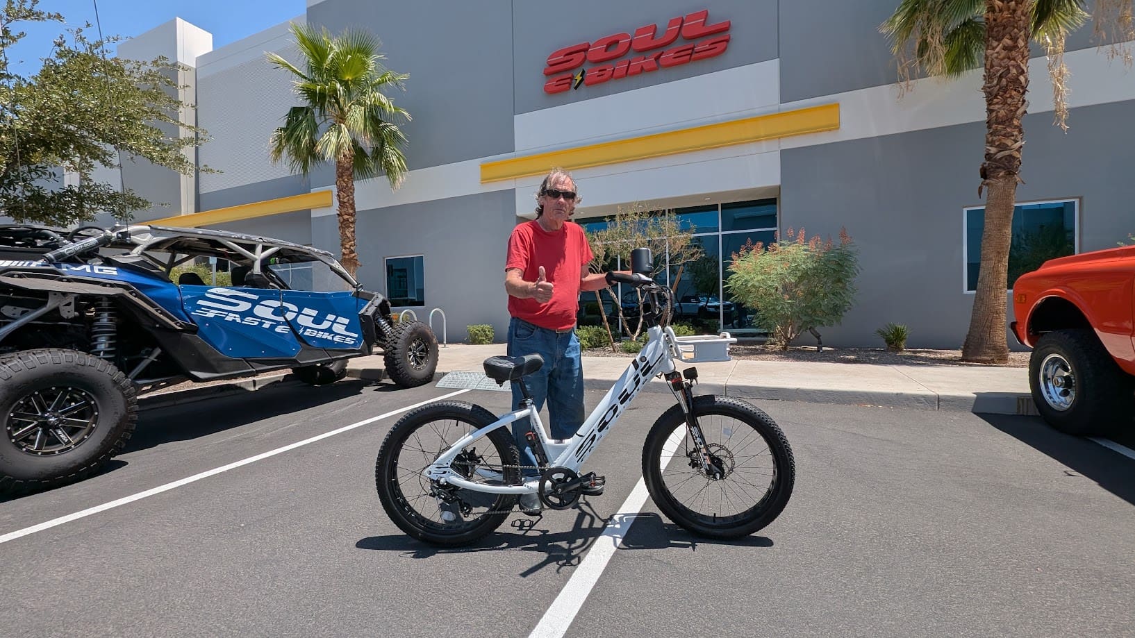 Person standing with a bicycle outside store.