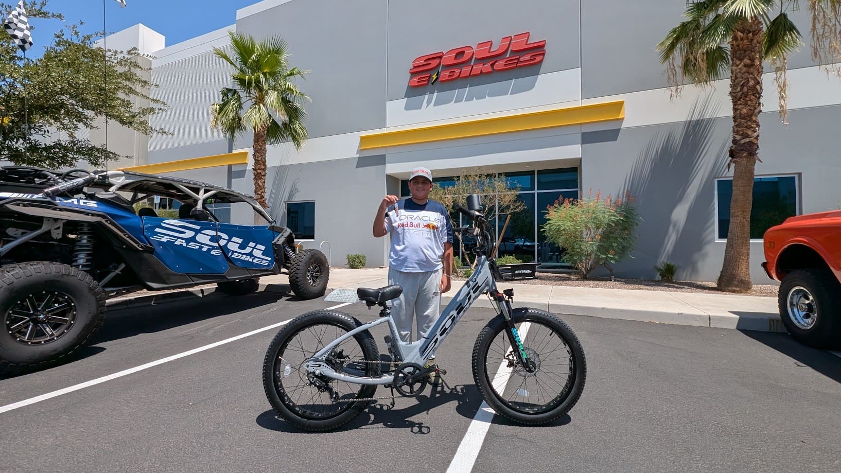 Man posing with a bicycle outside store.