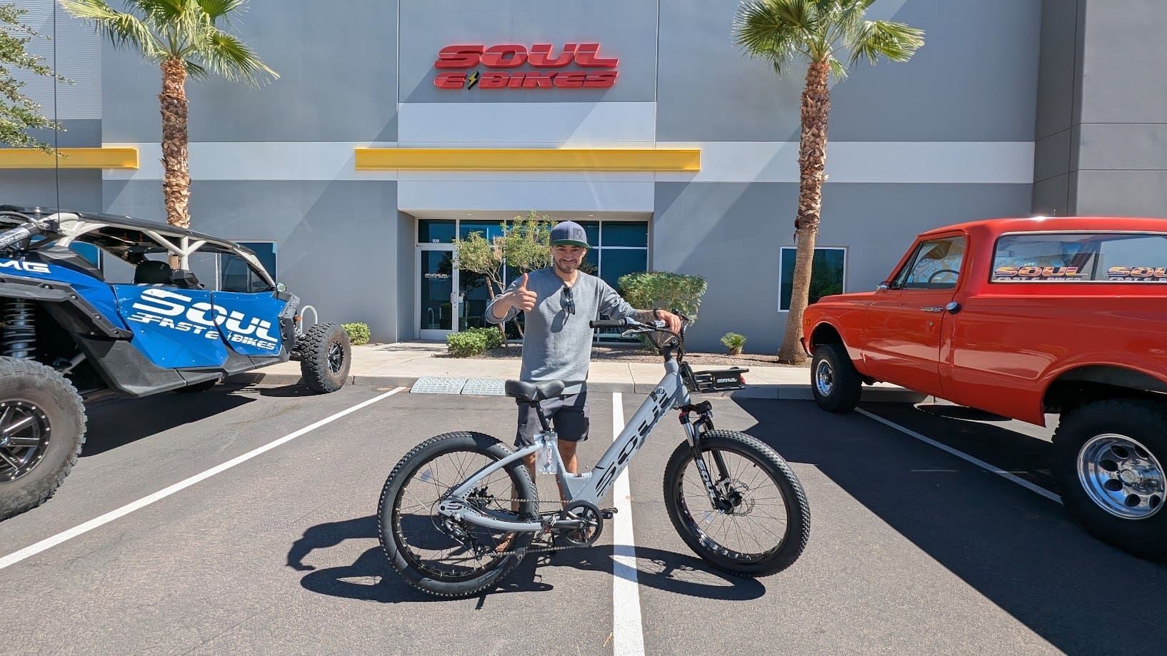 Man with bicycle outside Soul Cycles building.