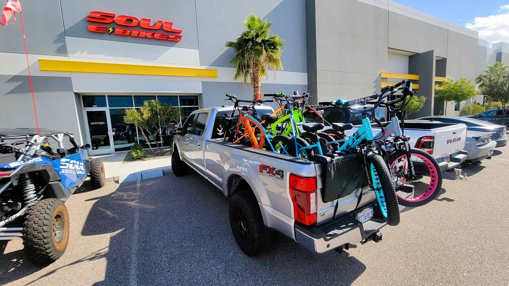 Truck loaded with colorful bicycles outside store.