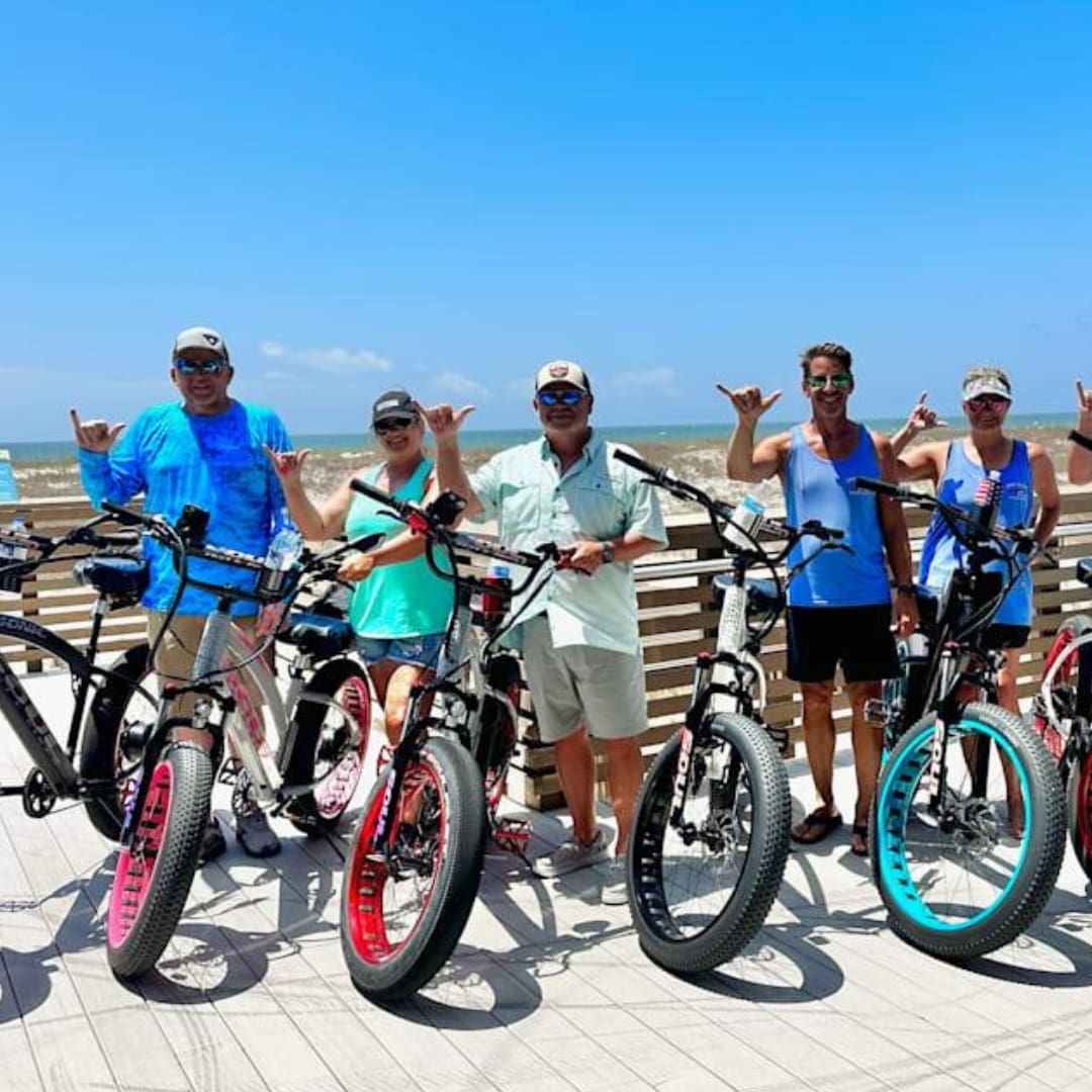 Group of people with bikes on boardwalk.