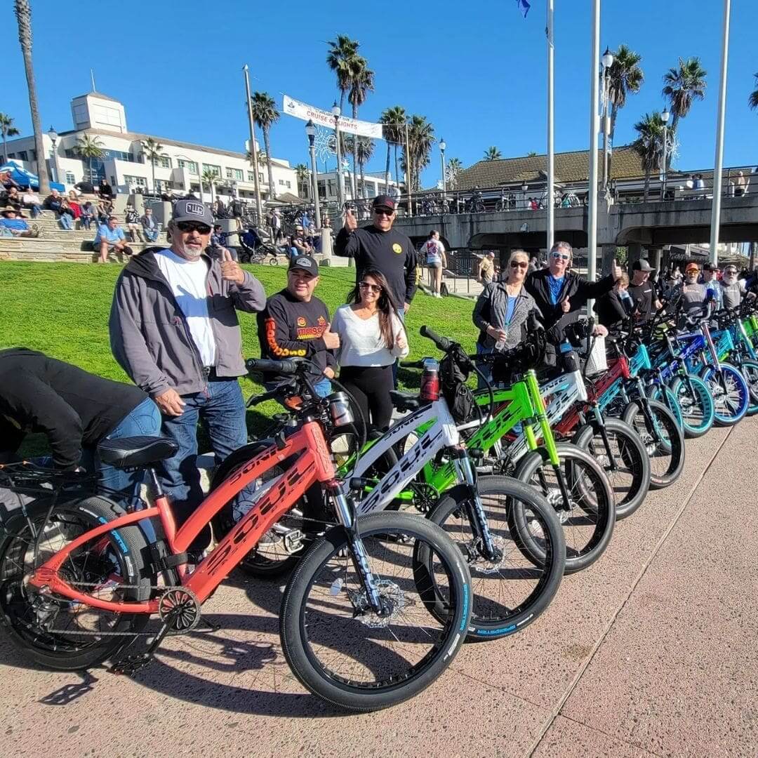 People with colorful bikes at a park.
