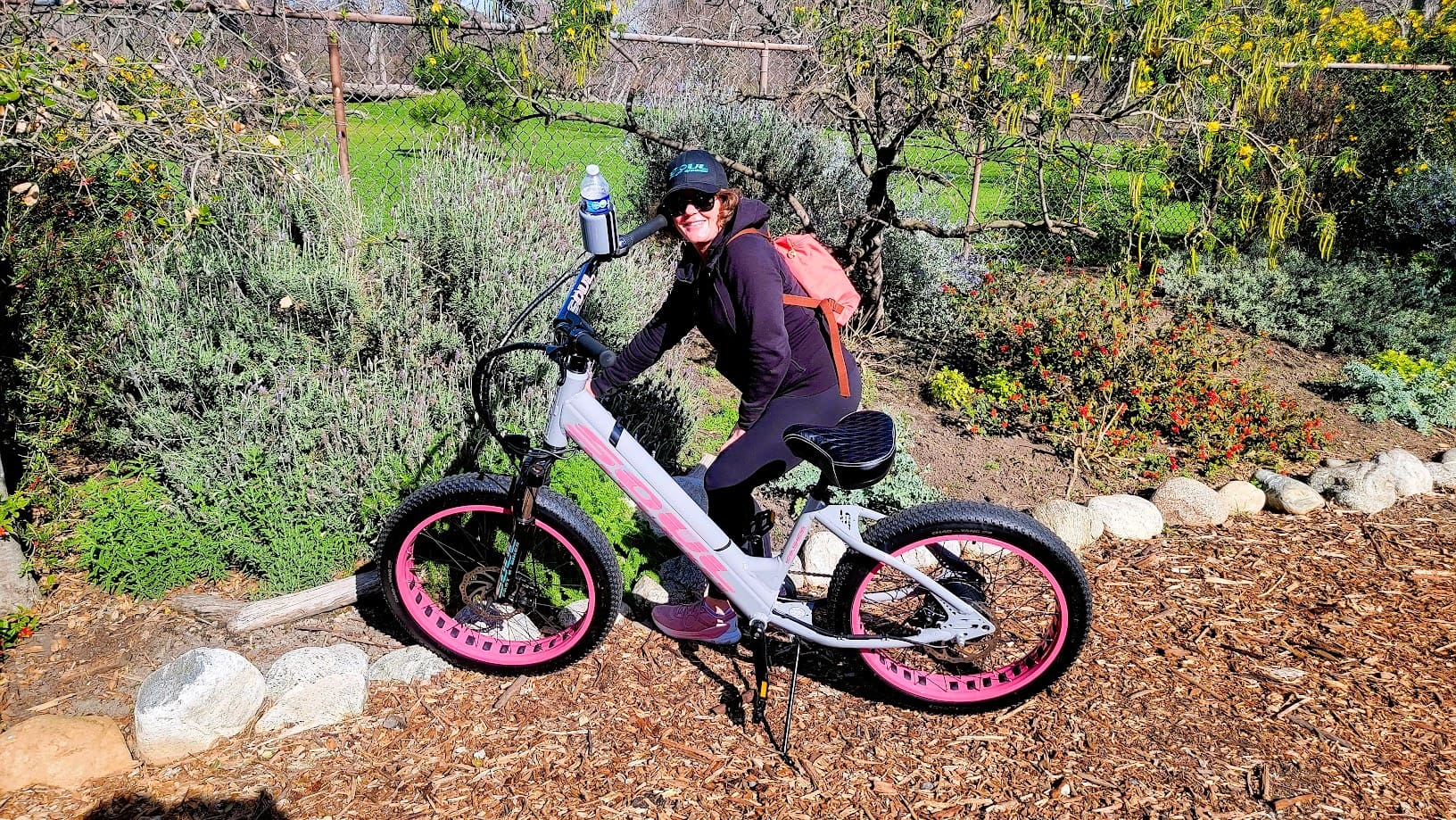 Person riding a bicycle in a garden.