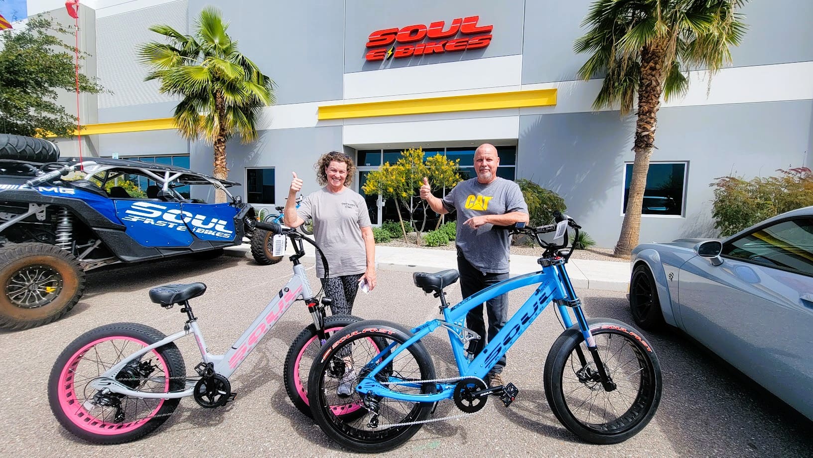 Two people with bikes outside Soul E Bikes.