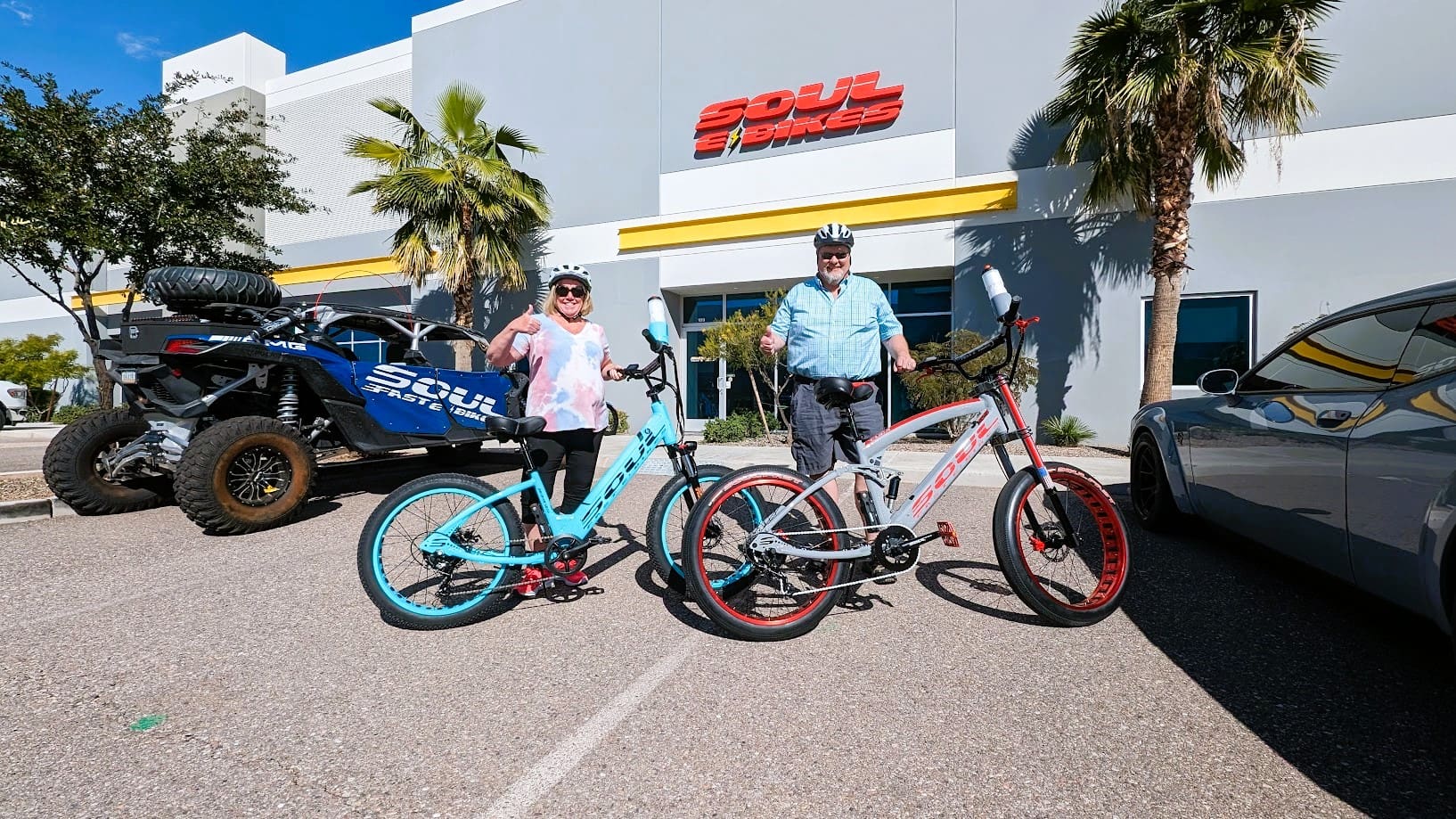 Two people with bicycles outside a building.
