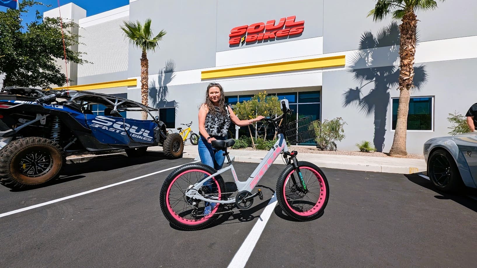Woman holding a bike outside Soul Bikes store.