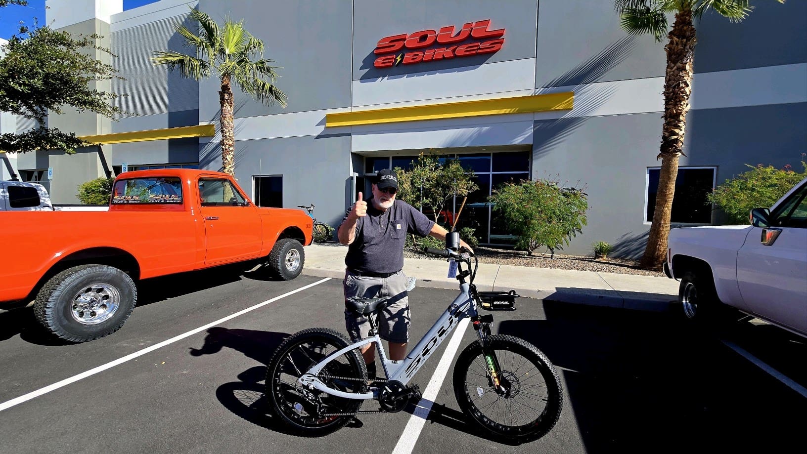 Man with bicycle outside Soul eBikes store.