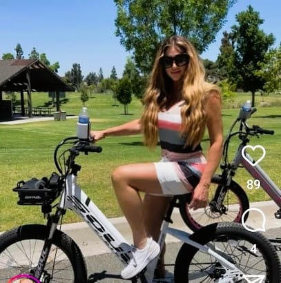 Woman sitting on a bicycle in park.