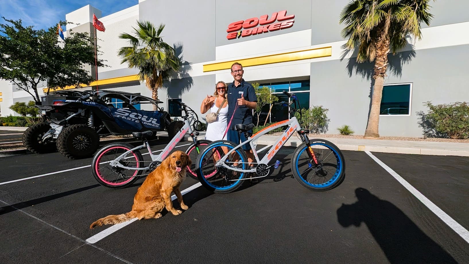 Couple with bikes and dog outside store.
