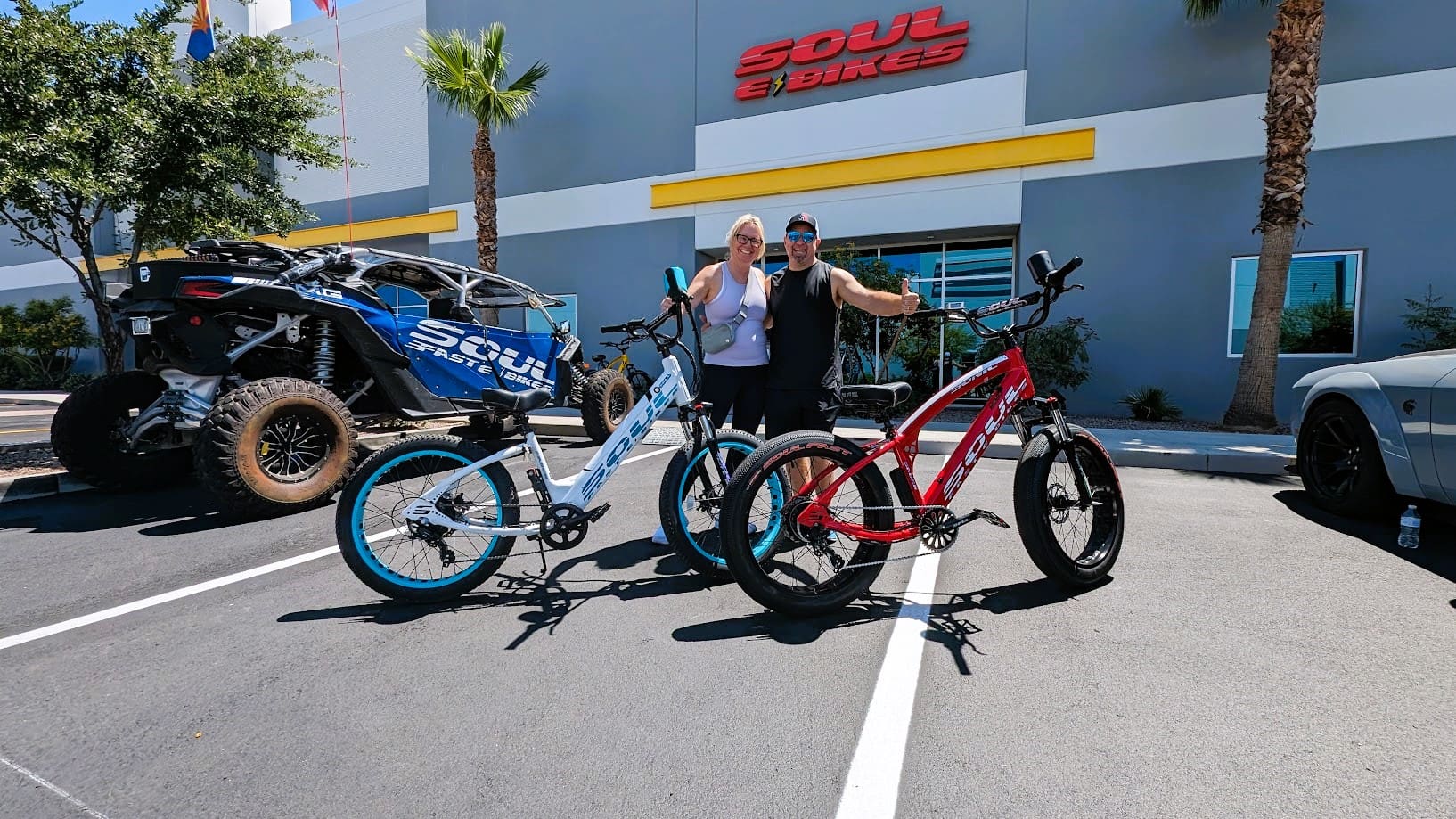 People with bicycles in front of store.