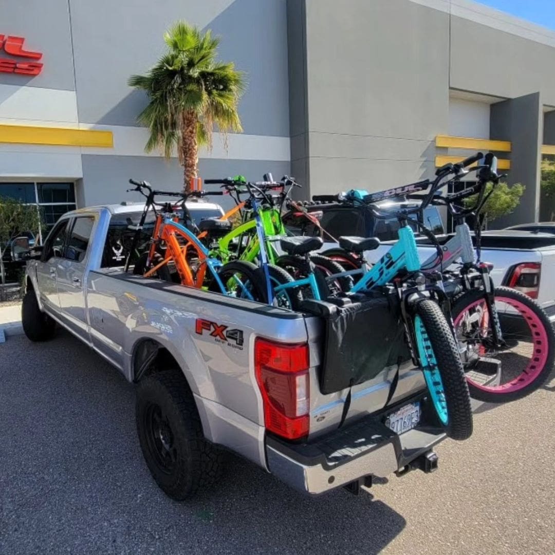 Truck loaded with multiple colorful bicycles.