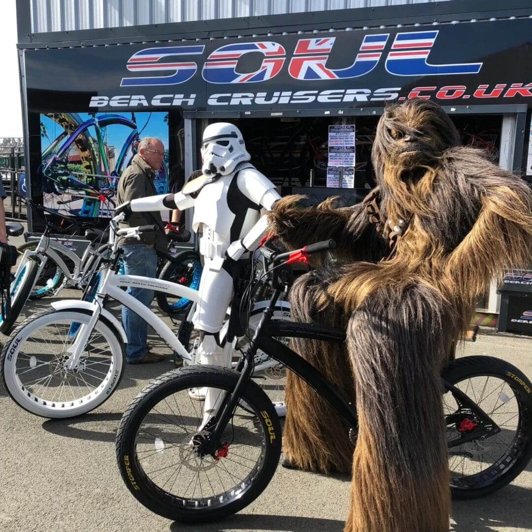 Stormtrooper and Wookiee posing with bicycles.