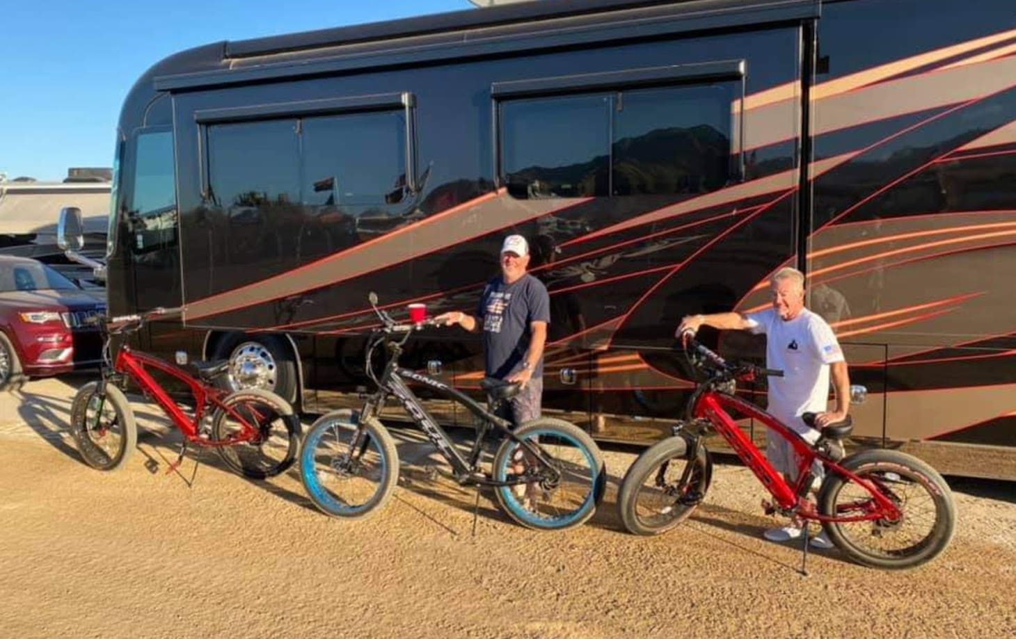 Two people with mountain bikes near RV.