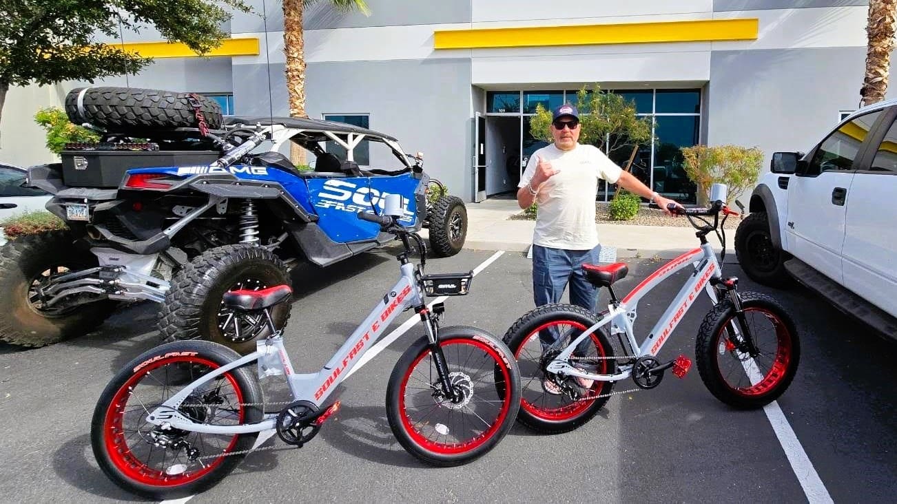Man with two electric bikes and vehicle.