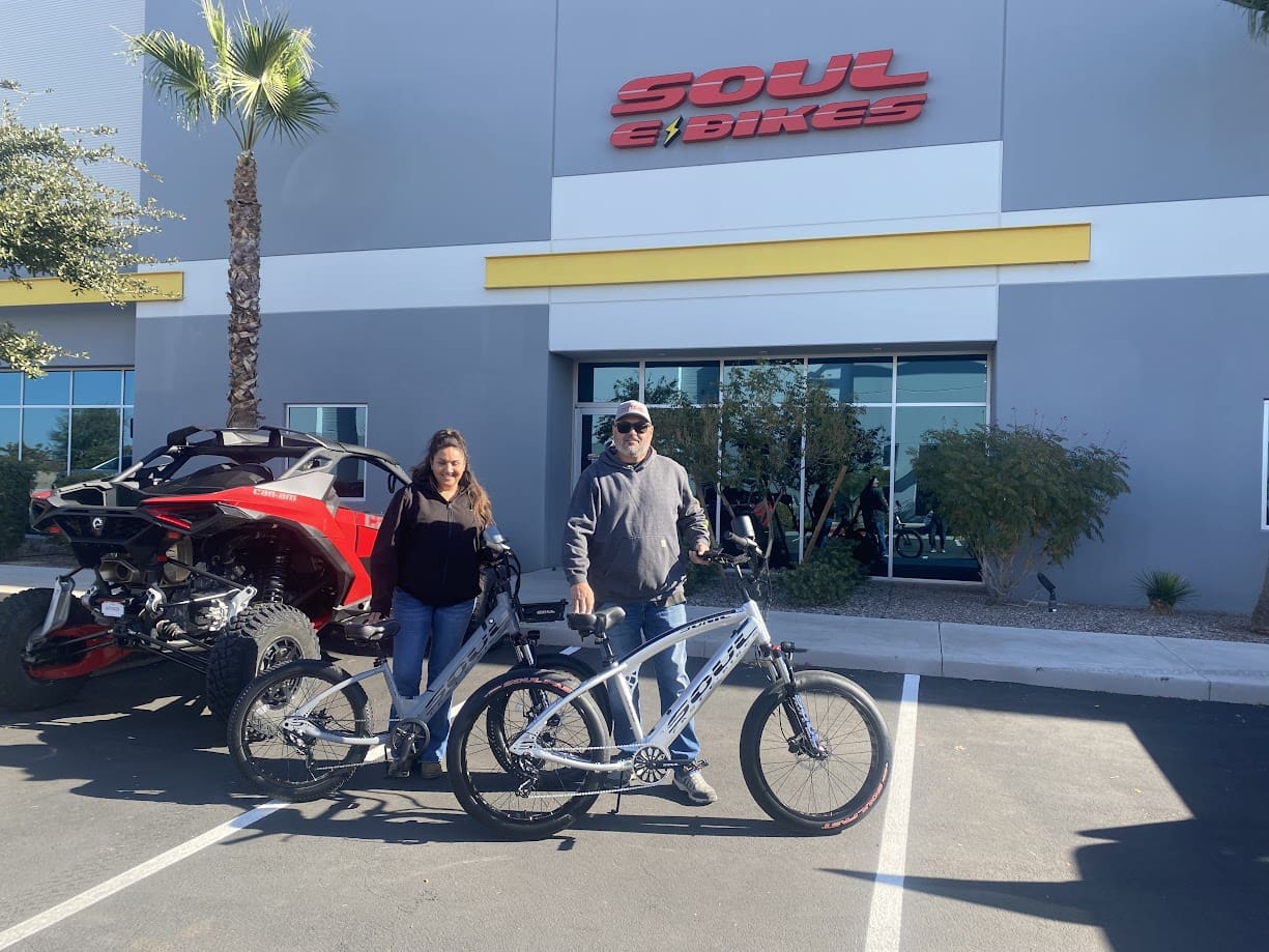 Two people with bikes outside a store.