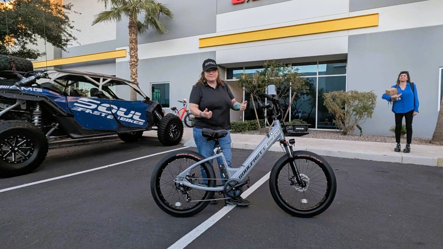 Person with electric bike in parking lot.