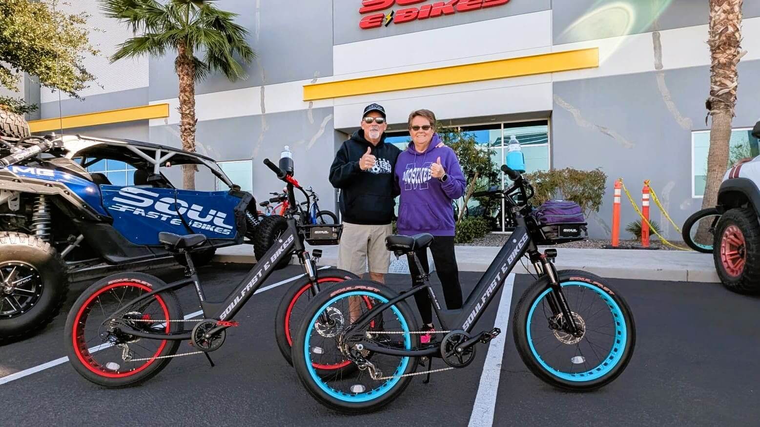 Couple with electric bikes in parking lot.