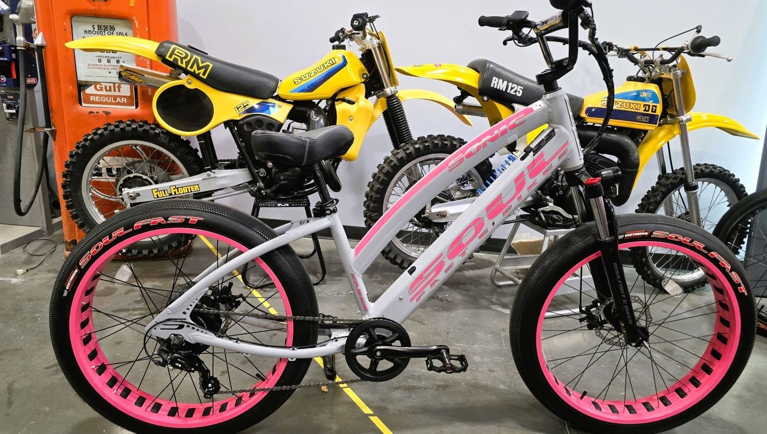 White bike with pink wheels, yellow motorcycles.